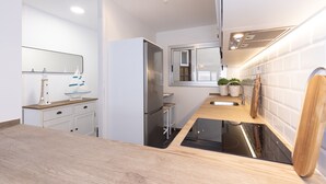 A modern kitchen with a wooden countertop, stainless steel appliances, and a built-in dishwasher.