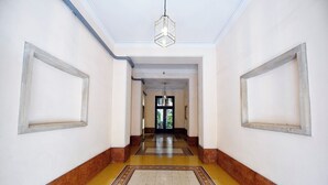 A hallway with a patterned floor, white walls, and a hanging light fixture. - Imperium penthouse with terrace (Roma)