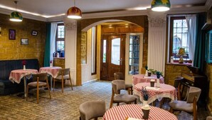 A cozy restaurant with checkered tablecloths, wooden furniture, and a stone wall. - Senator Boutique Hotel Baku (Baku)
