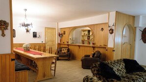 A cozy living room with a wooden dining table, a sofa, and a chair. - Visit Rome from a quiet place Frascati (Frascati)