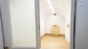 A room with a wooden floor, a white door, and a small wooden rack against the wall. - Visit Rome from a quiet place Frascati (Frascati)