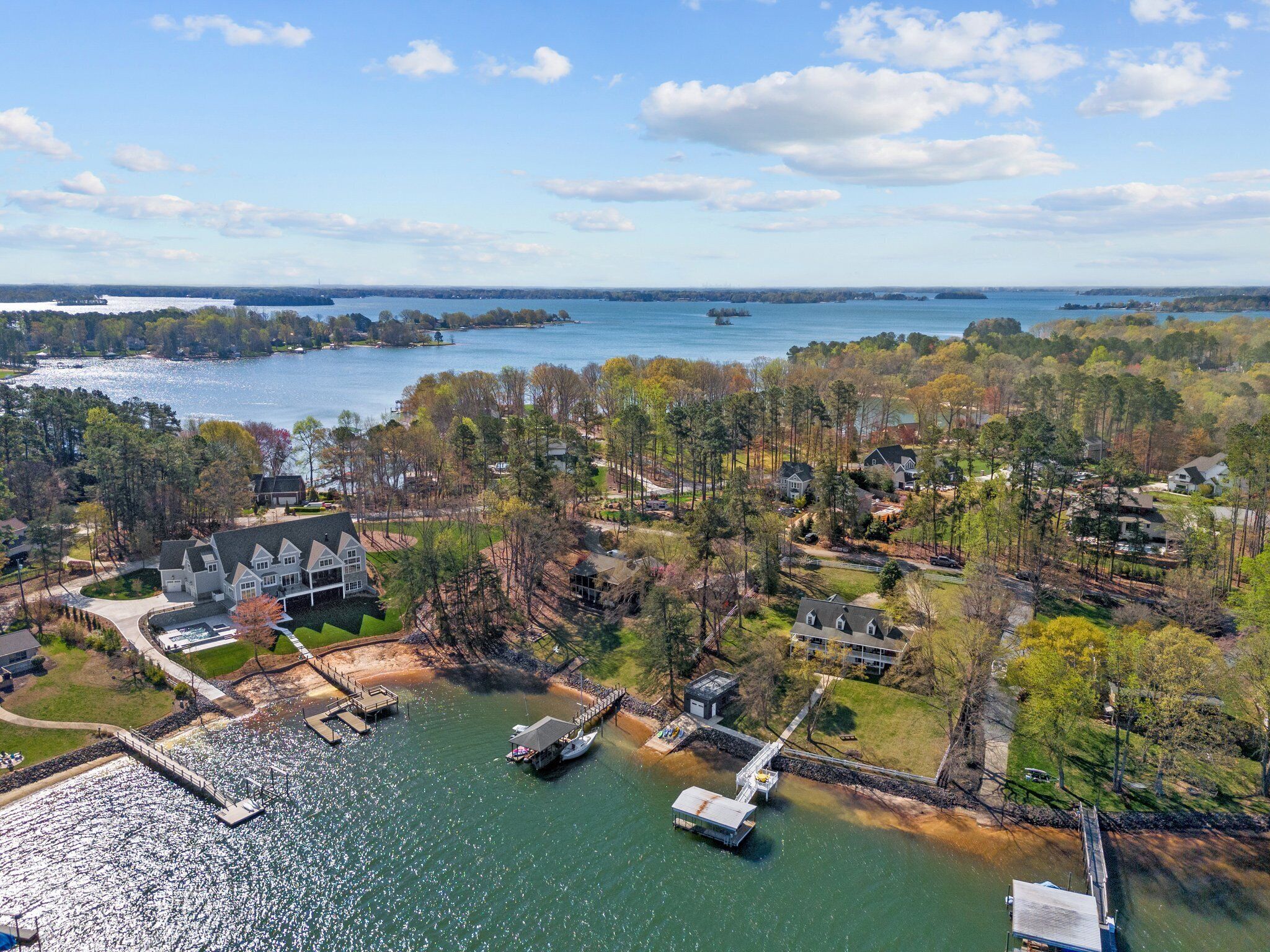 An aerial view of a lakeside community with residential properties, docks, and boats.