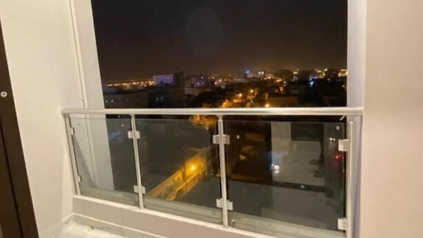 A balcony with a glass railing overlooking a cityscape at night. - RED-33 - Gardenia (Salalah)