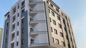 A multi-story building with balconies, large windows, and a flat roof. - RED-33 - Gardenia (Salalah)