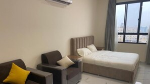 A hotel room with a bed, a sofa, and a chair. - RED-33 - Gardenia (Salalah)