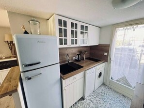 A compact kitchen with a white Amica refrigerator, a wooden countertop, a sink, and a washing machine. - MerBella Villa Comfort and Pool (Valras-Plage)