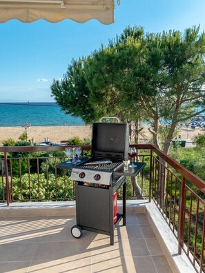 Un barbecue sur un balcon avec vue sur la plage et l’océan.