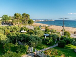 Une propriété située en bord de mer, dotée d’une allée pavée, d’une clôture blanche en bois et offrant une vue sur la mer.