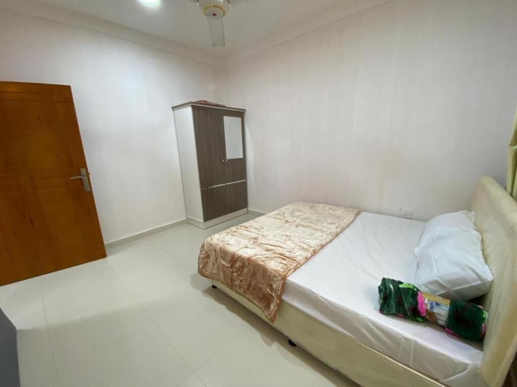 A bedroom with a bed, a wardrobe, and a door.