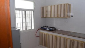 Una cocina pequeña con estufa a gas, armarios de madera y una ventana con vistas.