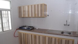 Una cocina con armarios de madera, estufa empotrada y un lavamanos.