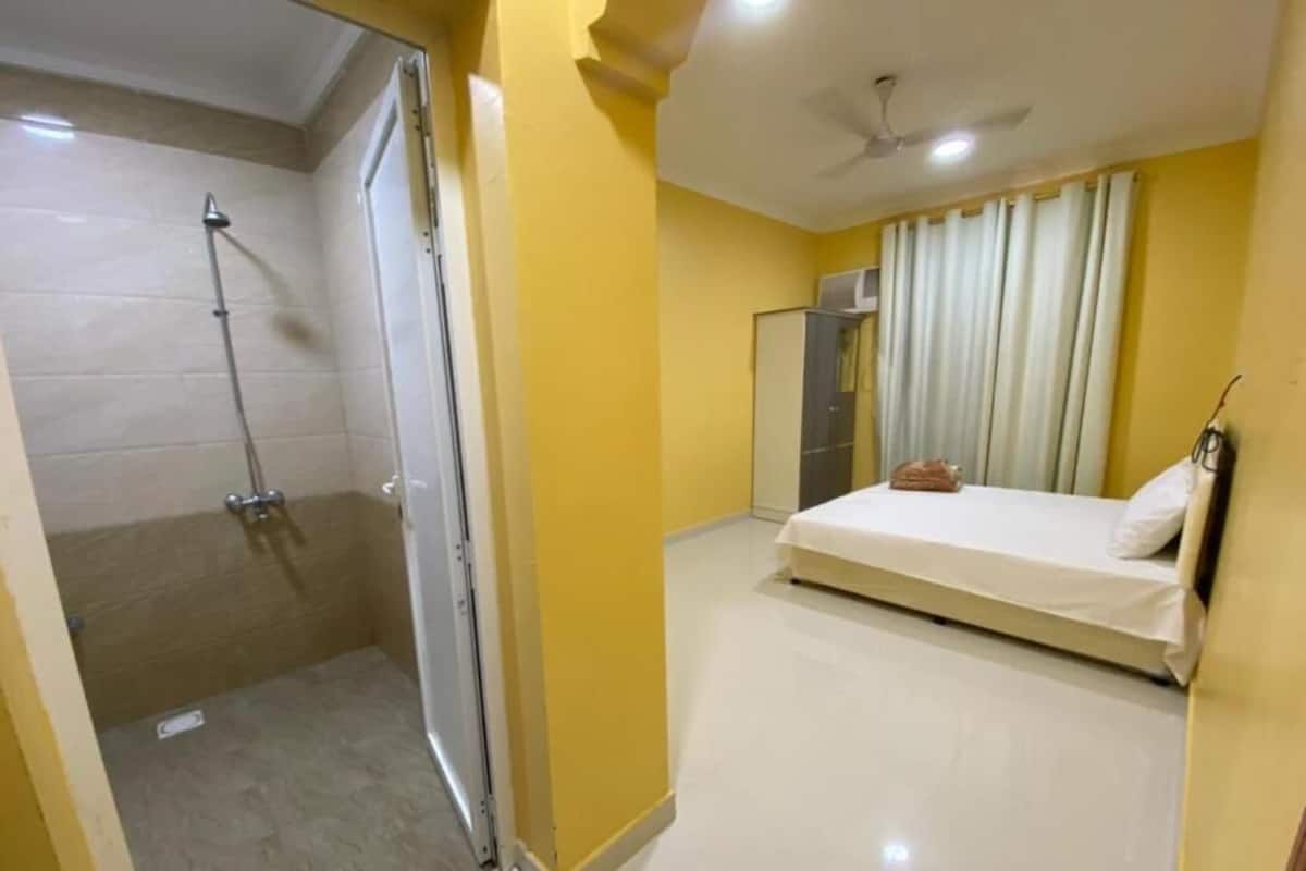 Une chambre avec une douche, un lit et une armoire.