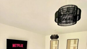 Un salon moderne avec un canapé, une table basse et un téléviseur affichant le logo « NETFLIX ».