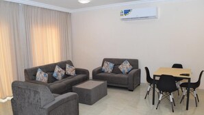 A living room with two sofas, a coffee table, and a dining table with chairs.