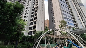 A high-rise building with multiple floors, surrounded by greenery and a playground structure. - Agile Residence Dual-Key Gem @ Bukit Bintang F11 By Natol (Kuala Lumpur)