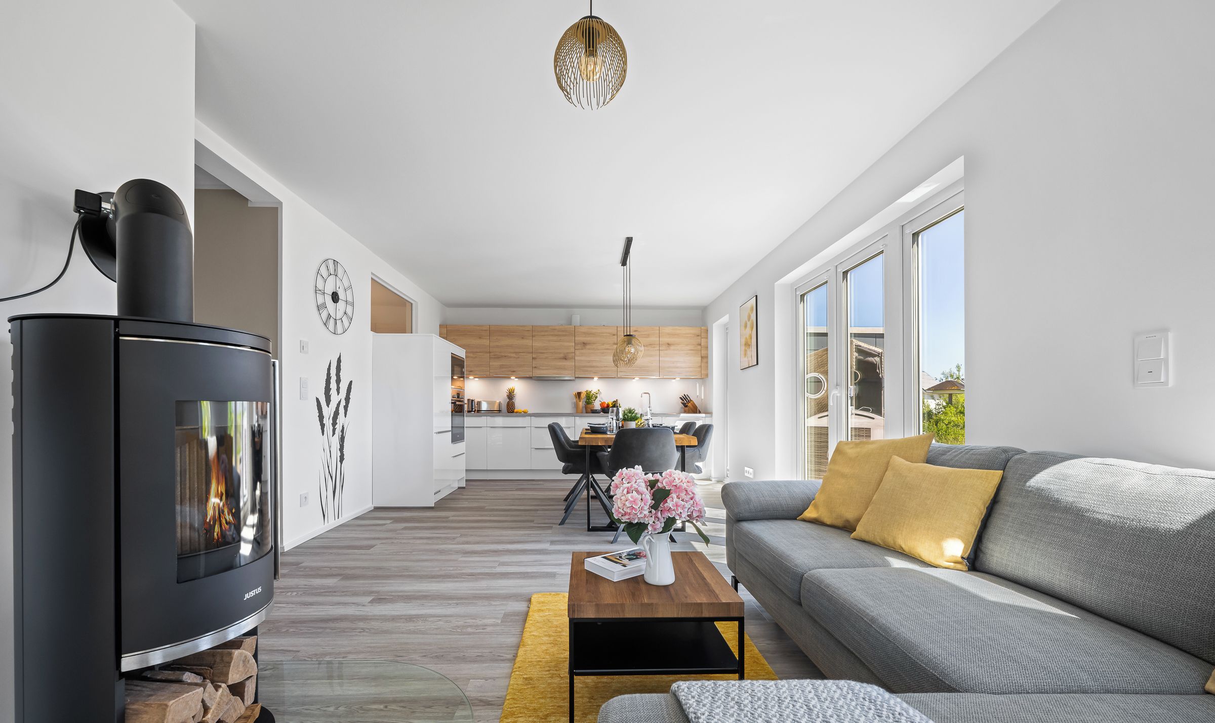 Una sala de estar moderna con chimenea, un sofá, una mesa de centro y un comedor al fondo.