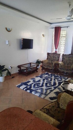 Family Apartment, City View | Living area | 32-inch Smart TV with digital channels