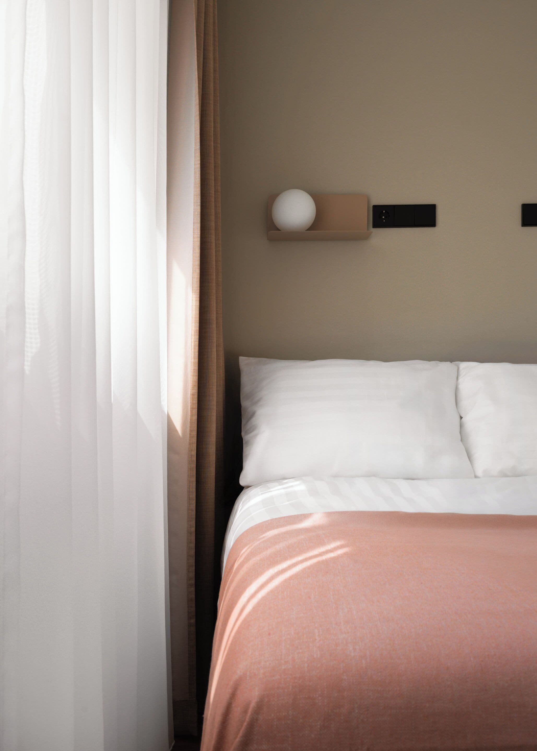 Una cama bien hecha con ropa de cama blanca y rosa, un estante en la pared con un objeto esférico y cortinas de encaje medio corridas.