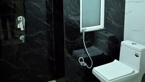 Un baño con inodoro, espejo y zona de ducha.