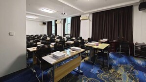 A conference room with rows of desks, chairs, and a projector screen. - Harbin Dashu Hotel (Harbin)