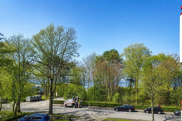 A parking area with trees, a tow truck, and parked cars.