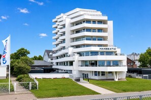 Een meerlaags gebouw met de naam 'HANSEATIC' op de gevel, met balkons, grote ramen en een plat dak.