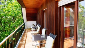 A covered outdoor patio with a table and chairs, a wooden ceiling, and a view of greenery. - KultUrlaub Mosel GbR (Kröv)