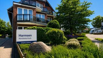 Un immeuble à plusieurs étages, sur lequel on peut lire les inscriptions « Harmsen Nordseearlauf » et « Vacances à Duhnen ».