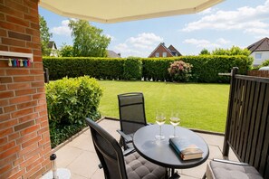 A patio with a table, two chairs, and a book titled 'Nordlich'.