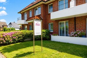Ein zweistöckiges Backsteingebäude mit der Aufschrift 'Haus Oasis'.