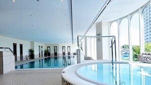 A modern indoor swimming pool with a separate hot tub area, large windows, and a tiled floor. - Vacation apartment Cuxhaven Döse on the beach | Lord Nelson No. 310 (Cuxhaven)