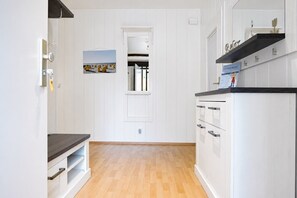 A modern kitchen with white cabinetry, a wooden countertop, and a built-in oven.