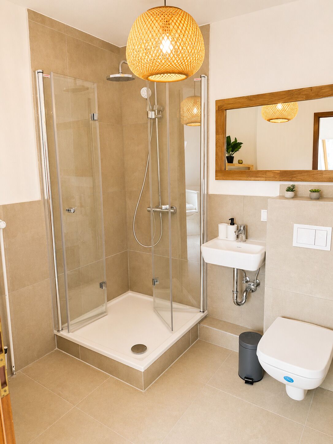Une salle de bain moderne avec une douche à parois de verre, un lavabo blanc et des toilettes.