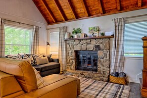 A cozy living room with a stone fireplace, leather sofas, and a plaid rug. - Rynns Retreat Mountain Views (Franklin)