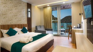 A hotel room with a large bed, a sofa, a dining area, and a balcony with a view. - Vinsober Kainchi Dham Nainital  (Kosiyakutoli)