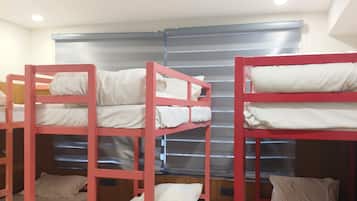 Camas literas en una habitación con ventana y una lámpara en el techo.