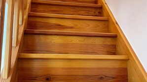 A wooden staircase with a handrail on the left side. - Family cottage with private terrace near Beauval (Meusnes)