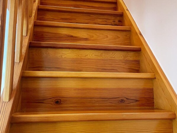 A wooden staircase with a handrail on the left side.