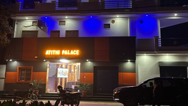 A building with a sign reading "Atithi Palace Luxury Guest House" and a visible entrance with a television screen. - Atithi Palace Luxury Guest House (Varanasi)