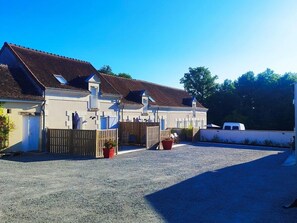 A row of white buildings with brown roofs, a gravel driveway, and a white van parked to the right. - Comfortable cottage with Wi-Fi, near Beauval Zoo and Loire castles (Meusnes)