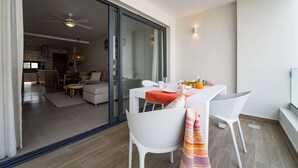 A modern living room with a glass door leading to a kitchen and dining area. - Beautiful new apartment steps from the beach (Punta Cana)
