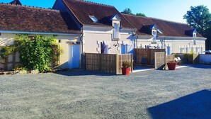A row of two-story houses with a gravel driveway and a wooden fence. - Comfortable cottages near Beauval with wifi and parking (Meusnes)