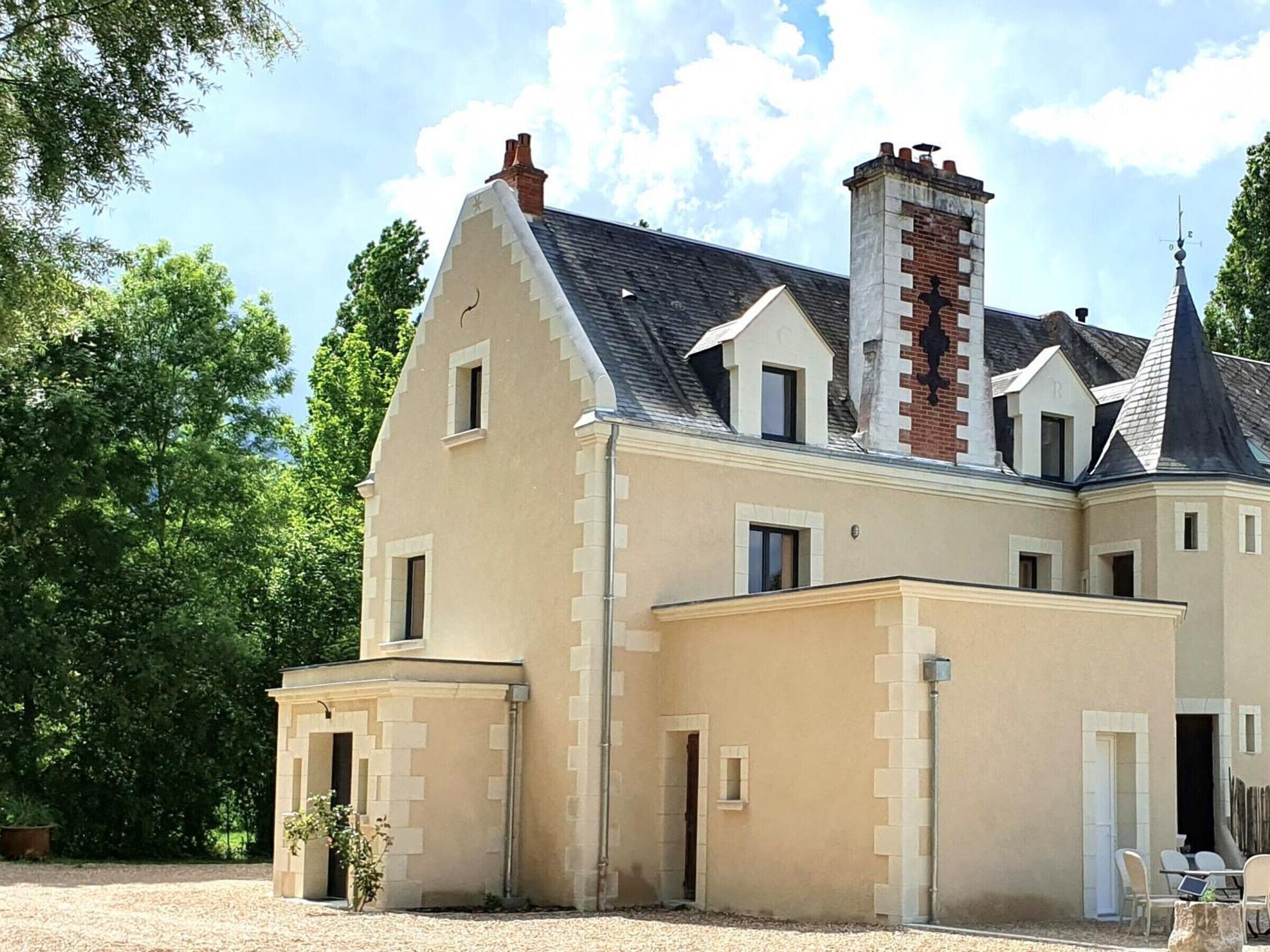 A large, two-story building with a symmetrical facade, multiple windows, and a prominent chimney.