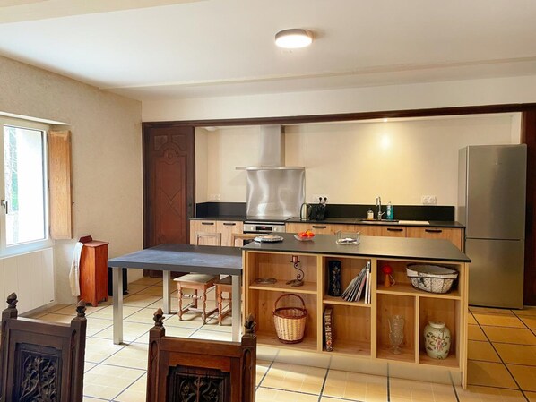 A modern kitchen with a central island, built-in oven, and stainless steel appliances. - The Ronsard Mill: Spacious house, garden, and Loir view - 8 people (Vallée-de-Ronsard)
