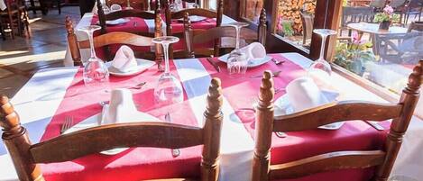 Une table à manger dressée avec des serviettes blanches, des verres à vin et des couverts.