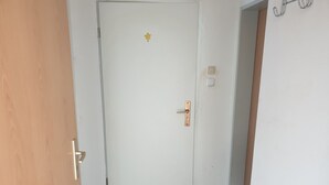 Una puerta blanca con una pegatina de estrella, un pomo metálico y una cerradura.