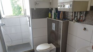 Un baño con inodoro, ducha y lavamanos.