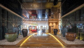 A modern hotel lobby with a wooden floor, large vases, and a central walkway. - Chengdu Joyhub Air Hotel (Chengdu)