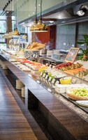 Un bufé con diversos alimentos y una larga barra.