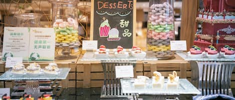 A dessert display with various sweets and a chalkboard sign.